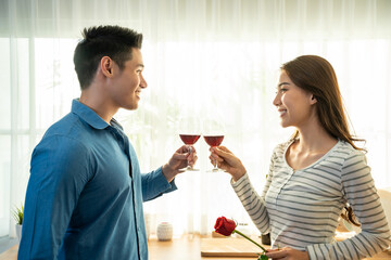 Asian young couple clinking glass of wine and drink on valentine's day
