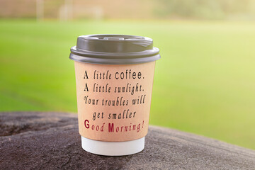 Text on brown color cup of take away coffee on top of big stone