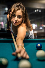 attractive woman hold cue and playing billiards