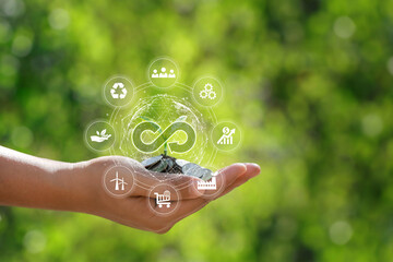  Green circular economy concept.circular economy icon circulating on hand holding a coin and a...