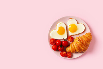 Healthy breakfast with eggs hearts and cup of coffee on pink background