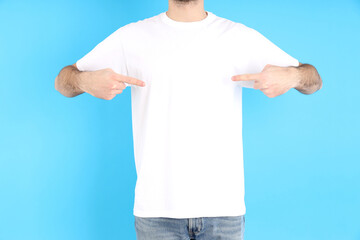 Man in blank white t-shirt on blue background