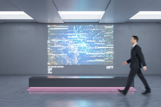 Businessman walking in abstract exhibition center with glowing polygonal NFT hologram. Technology, business and currency concept.