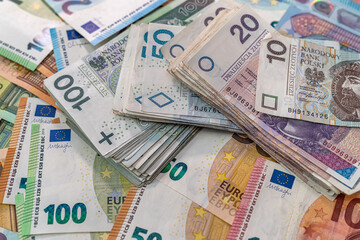 Obraz premium heap pile of euro bills with polish zloty as finance background