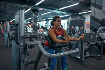 Fototapeta premium Girl lift weight on training apparatus for biceps