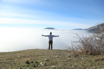 Obraz premium Traveler hiking in mountains clouds landscape