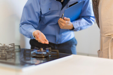 ガスコンロを点検する作業着の男性