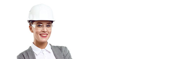 Young smiling successful female engineer with crossed arms wearing safety helmet and goggles on white isolated background