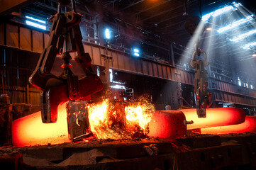 The red-hot metal casting is transported by a metallurgical crane