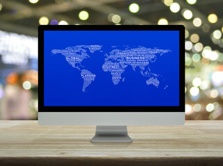 Global business words world map on desktop modern computer monitor screen on wooden table over blur light and shadow of shopping mall, Global business online concept, Elements of this image furnished 