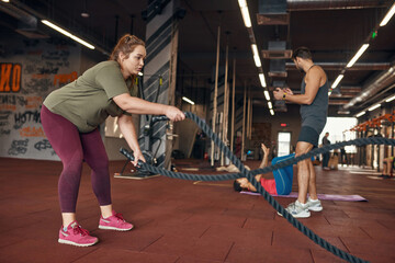 Fototapeta premium Trainer looking at girls training in sports center
