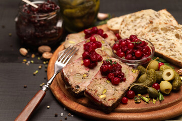 Sliced Traditional French terrine covered with bacon on dark wooden background