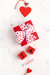 Valentine's day composition with gift box, hearts and ribbon on white background. Flat lay, top view. Greeting card mockup for Valentine's Day.