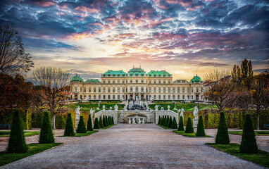 Panoramic evening view of the famous Belvedere Castle in Vienna, Austria. View of the fountain, park and Belvedere in the autumn evening. - obrazy, fototapety, plakaty