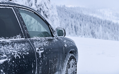 Fototapeta premium Frozen car and covered with snow and ice parked in a parking lot on top of a mountain resort