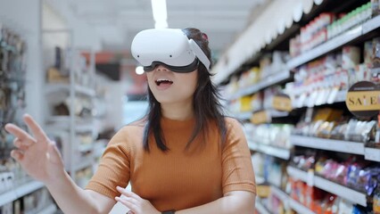 Exciting asian female wearing vr headset getting experience using VR-headset glasses walking through metaverse of virtual department store mall ,asian female enjoying  VR goggles virtual shopping