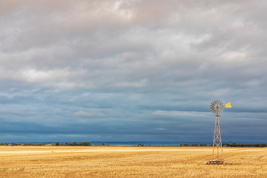 Cloudy sky over old windpump standing in field