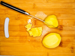 there is a slap in the face on a wooden board potatoes cut with a knife