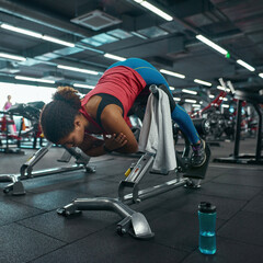 Fototapeta na wymiar Girl doing exercise on training apparatus in gym