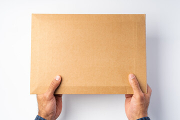 Obraz premium Male hand holding parcel post against white background