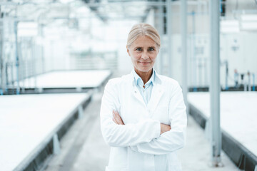 Confident biologist with arms crossed standing in laboratory