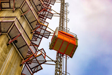 A construction elevator lifts workers to the height of a new cable-stayed bridge under construction. Construction equipment. The concept of high achievements. © Евгений Панов