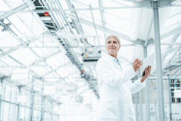 Thoughtful scientist in white lab coat at laboratory