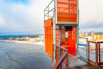 A landscape view of a construction elevator at the height of a construction site. The concept of high achievements.