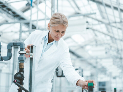 Agronomist adjusting knob on pipe at laboratory