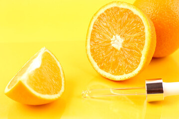 Pipette with orange essential oil over bottle and oranges. Natural medicine concept. Aromatherapy