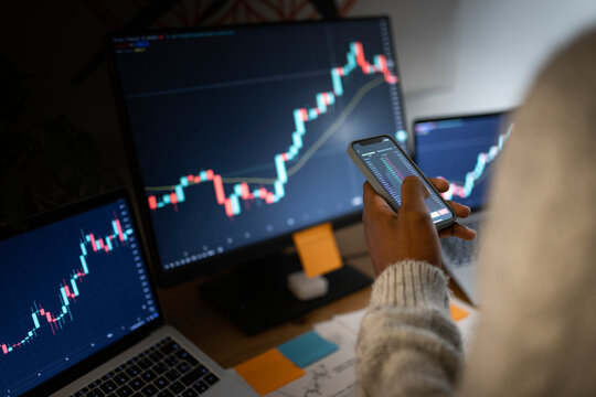 Stockbroker using smart phone for trading cryptocurrency at home office