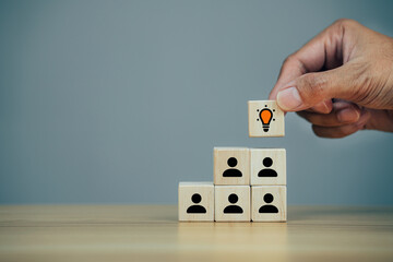 Hands holding idea cube with many human symbol, leadership and corporate hierarchy concept.