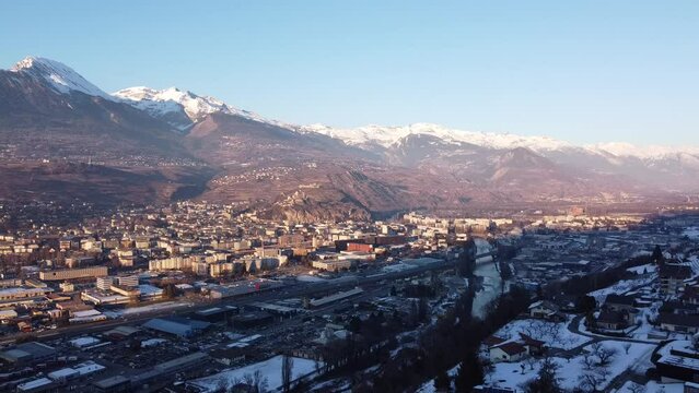 drone view over sion in the canton of valais in the swiss alps with snowy mountains in the evening sun
