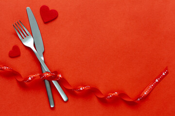 Red background with knife and fork, romantic date concept