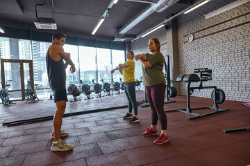 Fototapeta premium Girls and trainer stretching hands before training