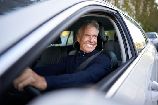 Smiling senior man driving car
