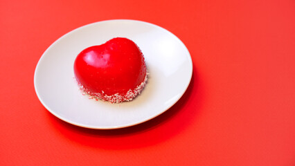 heart-shaped cake on a plate on a red background