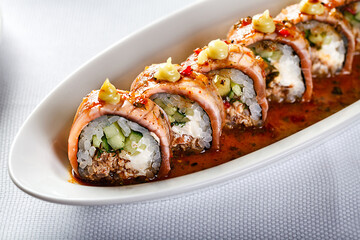Baked warm sushi rolls with eel, cucumber and smoked salmon