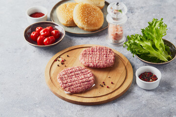 Raw veal mince Burger steak cutlets on wooden cutting board
