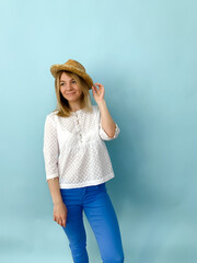 portrait of a cheerful woman in straw hat on blue background