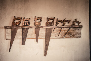 Row of rusted handsaw on wall