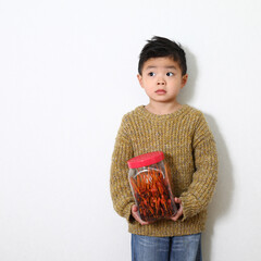 日本の伝統的な駄菓子「酢イカ」を持っている男の子。