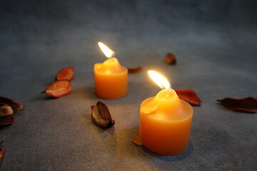 lit candles and petals on a gray background