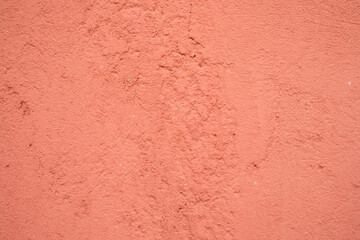 Light red textured plastered wall witch cracks and scratches, background, wallpaper, pattern.