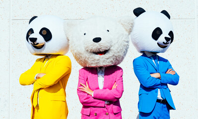 Storytelling image of a group of friends wearing giant panda head. Men and  a woman celebrating...