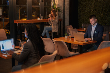 Business people working on their devices while drinking coffee in the cafe