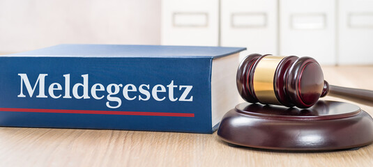 Gesetzbuch mit Richterhammer - Meldegesetz