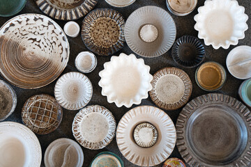 Plates, saucers and saucers made of handmade ceramics on a gray background. Top view, flatlay.