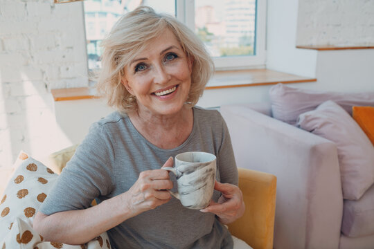 Elderly caucasian old granny aged woman enjoying afternoon tea at home