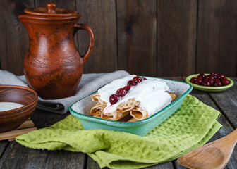 Homemade pancakes with cherries on a wooden table in a rustic style